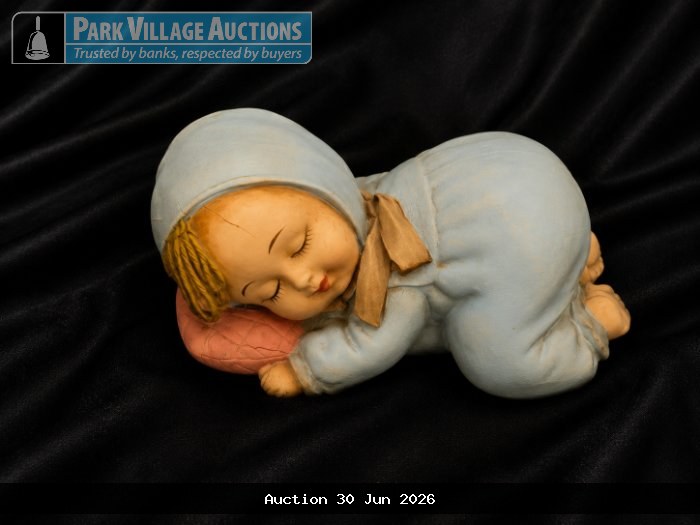 SLEEPING BABY FIGURINE IN A BLUE OUTFIT, RESTING ON A PINK PILLOW
