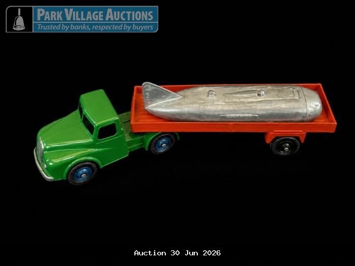 LONE STAR GREEN DIE-CAST FLATBED TRUCK WITH AN ORANGE TRAILER CARRYING A SILVER ROCKET-SHAPED LOAD,