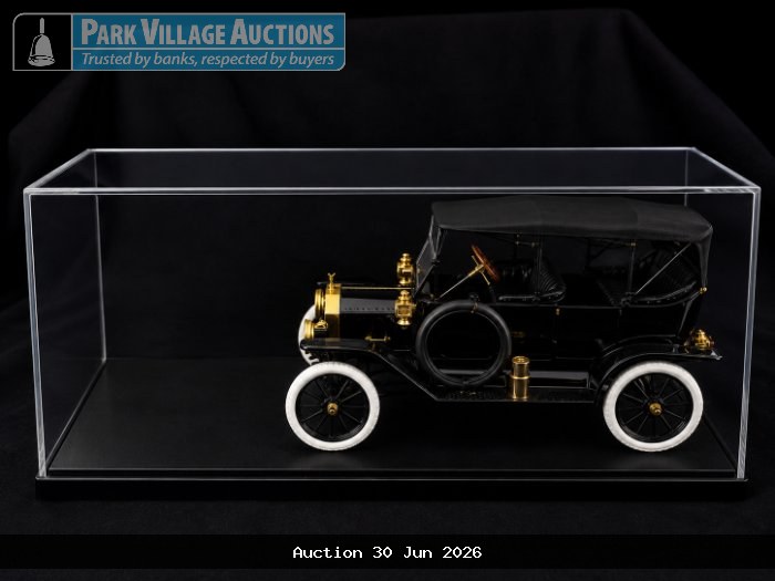 BLACK VINTAGE-STYLE DIE-CAST CLASSIC TOURING CAR MODEL WITH GOLD DETAILING AND WHITEWALL TYRES, PRESENTED IN A CLEAR DISPLAY CASE.